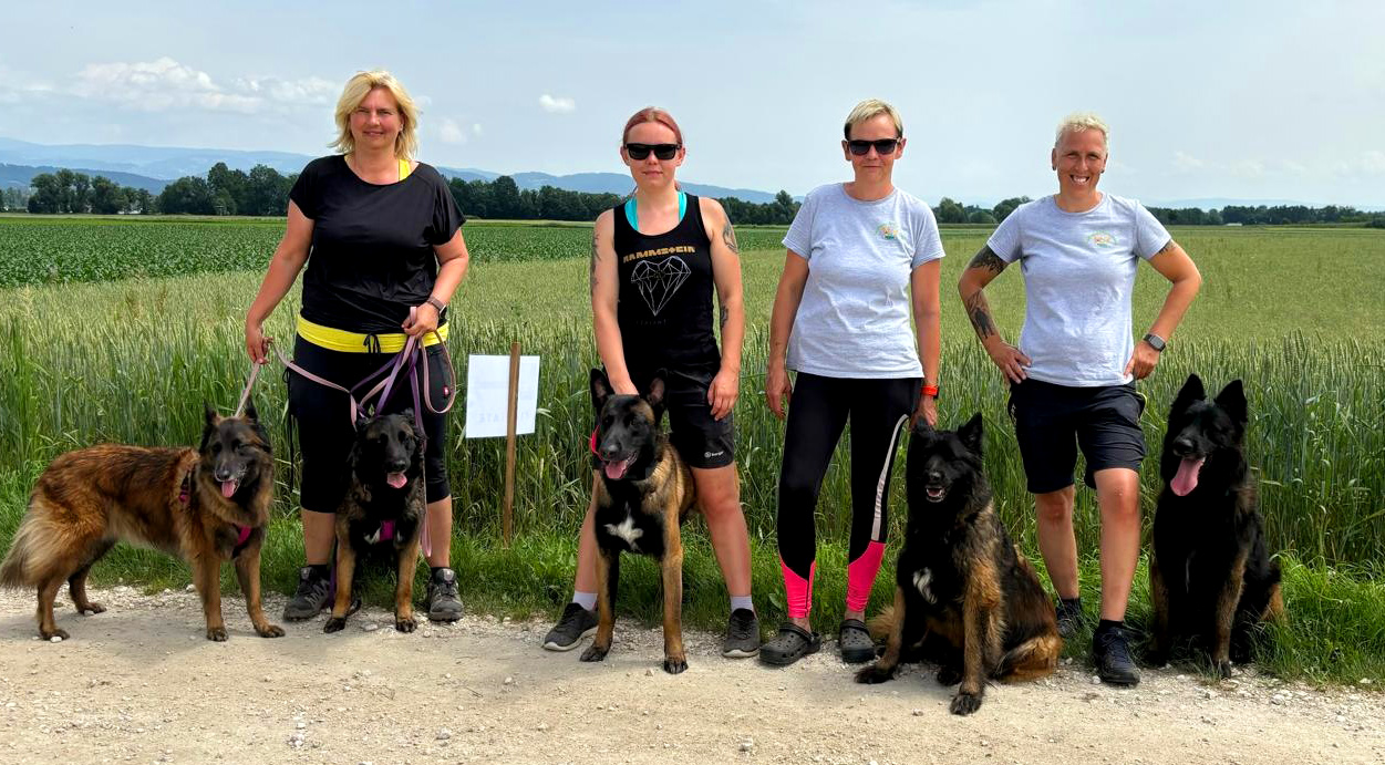 4 Personen mit Hund stehen vor einem Feld
